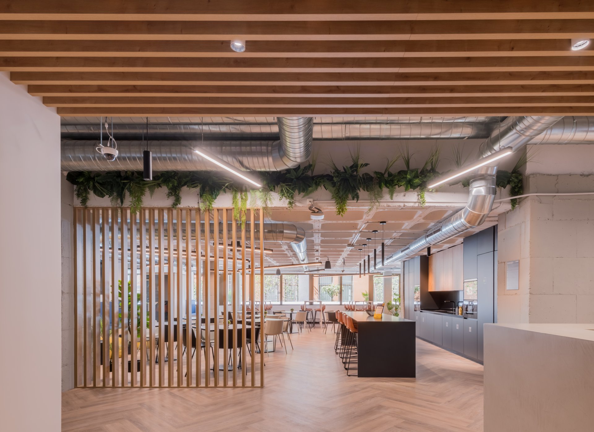 Vista amplia de una oficina flexible que muestra los costes de una mudanza de oficina para una startup, incluyendo cocina y zona de trabajo.