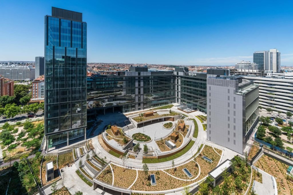 Vista aérea de un moderno complejo de oficinas para startups en la zona emergente de Arganzuela, Madrid, con zonas verdes y diseño innovador